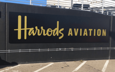 A black Harrods sign applied to a wall.